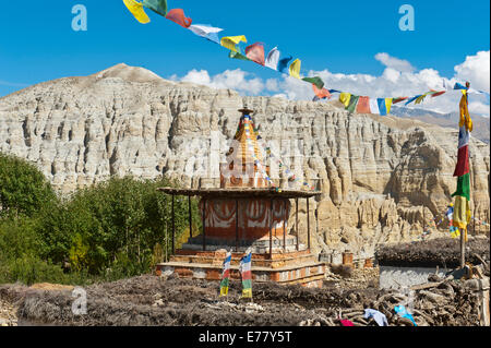 Stupa bouddhiste orné de couleurs avec les drapeaux de prières colorés, paysage érodé à l'arrière, Charang, Mustang, Népal Banque D'Images