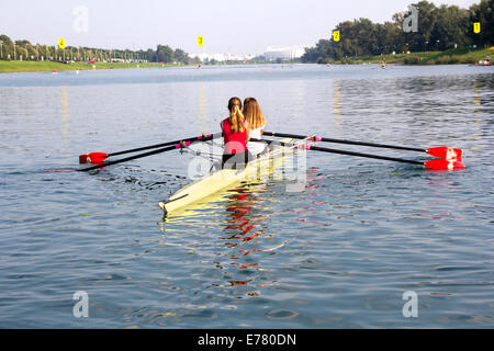 Deux jeunes filles dans un bateau, les palettes sur le paisible lac Banque D'Images