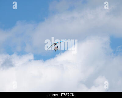 Avion ultra-léger dans le ciel bleu avec des nuages, Jura, France Banque D'Images