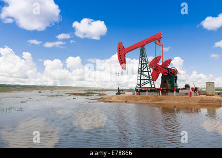 Une pompe à huile rouge par le Riverside Banque D'Images