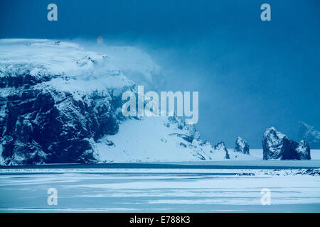 La pointe et la mer des piles de Dyrhólaey dans l'hiver, le sud de l'Islande Banque D'Images