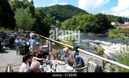 Les gens de manger dehors au moulin à maïs de restaurant sur la rivière Dee en été Llangollen Denbighshire North Wales UK KATHY DEWITT Banque D'Images