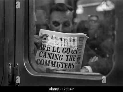 Les banlieusards de la lecture du journal du soir sur une région du Sud train retardé dans la gare de Charing Cross. Banque D'Images