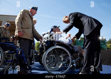 Le président américain Barack Obama salue DES VÉTÉRANS DE LA SECONDE GUERRE MONDIALE sur scène lors de la 70e Commémoration franco-américaines D-Day Cérémonie au cimetière américain de Normandie le 6 juin 2014 à Colleville-sur-Mer, France. Banque D'Images