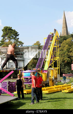 Witney, Oxfordshire, UK, le 9 septembre 2014. Les travailleurs forains créé un soleil de plomb en suspension dodgem en préparation de la fête à Witney ce weekend. La fête annuelle de St Mary a eu lieu depuis 1243 pour commémorer la nouvelle inauguration de l'église St Mary lorsque l'évêque a donné un cerf au Recteur afin que les gens de la ville ne pouvait célébrer l'occasion. Aujourd'hui un cochon rôti le vert de l'Église marque encore cette partie de la tradition aux côtés des manèges forains, sideshows, stands de nourriture, de la musique, et les événements sportifs Credit : Ric Mellis/Alamy Live News Banque D'Images