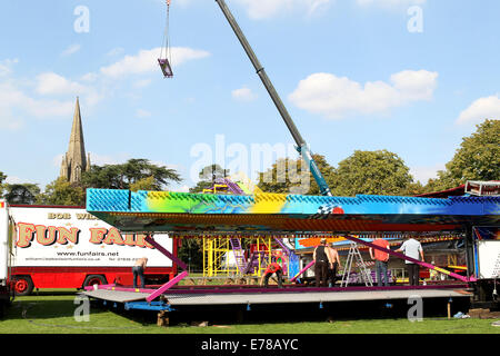 Witney, Oxfordshire, UK, le 9 septembre 2014. Les travailleurs forains créé un soleil de plomb en suspension dodgem en préparation de la fête à Witney ce weekend. La fête annuelle de St Mary a eu lieu depuis 1243 pour commémorer la nouvelle inauguration de l'église St Mary lorsque l'évêque a donné un cerf au Recteur afin que les gens de la ville ne pouvait célébrer l'occasion. Aujourd'hui un cochon rôti le vert de l'Église marque encore cette partie de la tradition aux côtés des manèges forains, sideshows, stands de nourriture, de la musique, et les événements sportifs Credit : Ric Mellis/Alamy Live News Banque D'Images