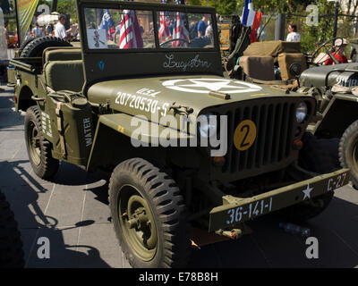 American Vintage une jeep de la Seconde Guerre mondiale battant le drapeau américain dans une commémoration de la libération de la France. Banque D'Images