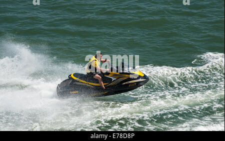 Course le long de l'homme dans l'eau sur un jetski. Banque D'Images