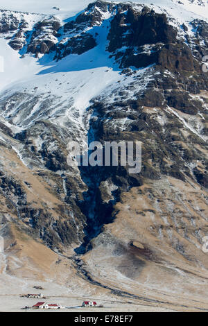 Farmhouses éclipsées par la masse de glace, le sud de l'Islande Eyjafjallajökull Banque D'Images