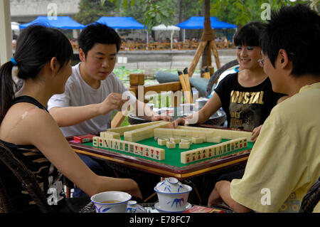 Quatre jeunes joueurs du jeu traditionnel chinois Mah Jonng dans la culture Parc de Chengdu Banque D'Images