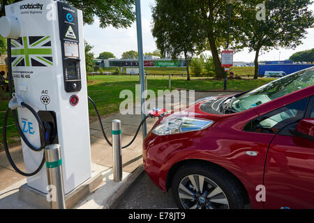 La Nissan LEAF Voiture électrique d'être facturés dans le parking à Warwickshire UK Services Corley Banque D'Images