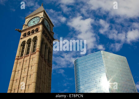 La tour de l'horloge - historique de l'hôtel de ville de Toronto - et le nouveau gratte-ciel de verre et d'acier avec bien reflétée dans la surface du bâtiment Banque D'Images