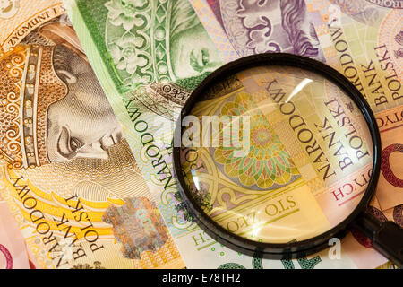 La fausse monnaie concept. Polish zloty Billets Monnaie et loupe Banque D'Images