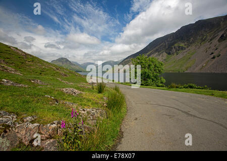 Lac Wastwater road et entouré de sommets de montagnes recouvertes de végétation verte, ciel bleu, Lake District, Cumbria, Angleterre Banque D'Images