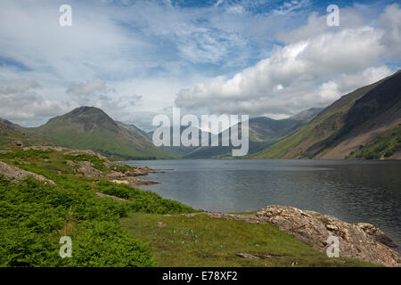 Lac Wastwater entourée de sommets de montagnes recouvertes de végétation verte, ciel bleu avec des nuages bas, Lake District, Cumbria England Banque D'Images