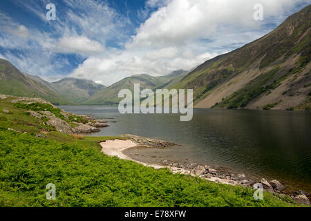 Lac Wastwater entourée de sommets de montagnes recouvertes de végétation verte, ciel bleu avec des nuages bas, Lake District, Cumbria England Banque D'Images