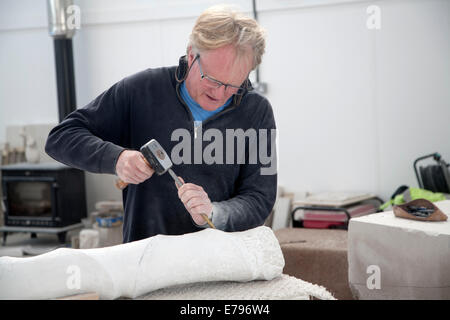 Sculpteur de pierre de Portland locale travaillant sur un espace communautaire en studio sur l'Île de Portland, Dorset, Angleterre Banque D'Images