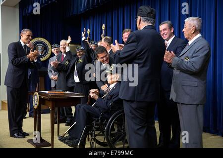 Le président américain Barack Obama applaudit après avoir signé H.R. 1726, octroi d'une médaille d'or du Congrès pour le 65e Régiment d'infanterie, connu comme les Borinqueneers, dans le Eisenhower Executive Office Building Auditorium Cour du sud de la Maison Blanche le 10 juin 2014 à Washington, DC. Banque D'Images