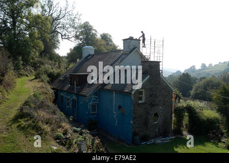 Carmarthenshire Wales UK, 10 septembre 2014. En continuant à sec ensoleillé chaud Ben Shipman se dresse sur un échafaudage pour réparer une cheminée sur une maison en milieu rural campagne galloise en préparation pour l'hiver. Travailler avec lui sont Thea Champion et Penny Shipman. Kathy de Witt/Alamy Live News Banque D'Images