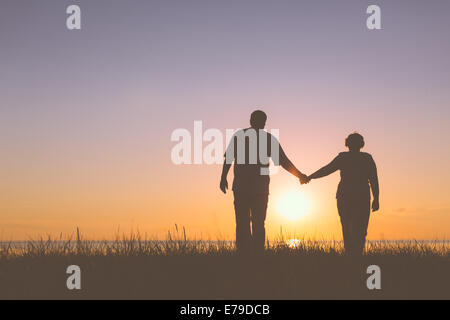 Senior couple holding hands silhouettes Banque D'Images