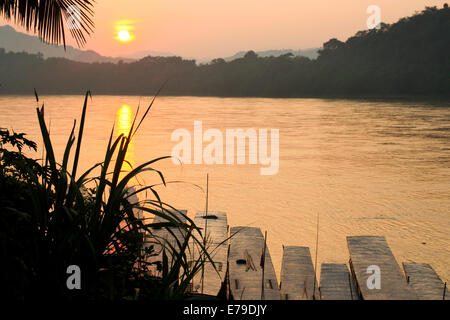 Le soleil commence à se coucher sur la jungle dense comme une autre journée se termine à Luang Prabang. Banque D'Images