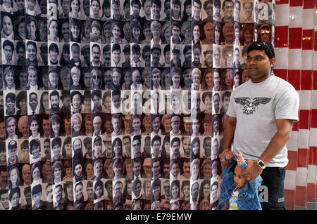 Mur de photos dans l'Ellis Island Immigration Museum à proximité de Manhattan New York City New York USA Amérique du Nord. Ellis Island. Cette île était la porte principale pour tous les immigrants qui arrivent à New York à partir de 1892-1954. À l'heure actuelle, et basées sur des photographies, des bagages et des marchandises semblables à ces immigrants exerçant son activité sous l'un peut faire une assez bonne idée de ce qu'ils ont vécu. L'endroit dispose également d'un ordinateur dans lequel après avoir mis le nom complet d'un membre de la famille, il recherche dans la base de données dans l'existence et la date je passe par ces installations. Banque D'Images