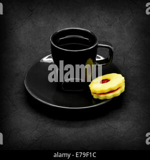 Tasse de café noir sur un fond gris et fissuré cookie avec de la confiture. Banque D'Images