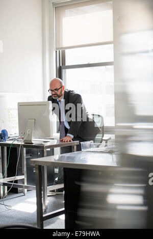 La vie de bureau. Un homme travaillant seul dans un bureau. Banque D'Images