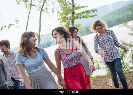 Un groupe de personnes bénéficiant d'une agréable promenade par un lac. Banque D'Images