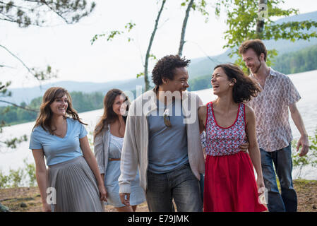 Un groupe de personnes bénéficiant d'une agréable promenade par un lac. Banque D'Images