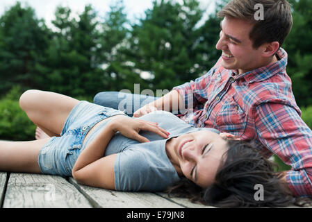 Un couple de détente sur une jetée donnant sur un lac de montagne. Banque D'Images