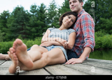 Un couple de détente sur une jetée donnant sur un lac de montagne. Banque D'Images