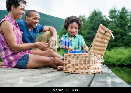 Une famille ayant un pique-nique d'été au bord d'un lac. Banque D'Images