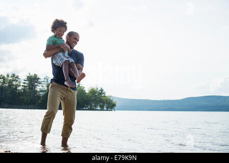 Un père et son fils, sur une rive du lac en été. Banque D'Images