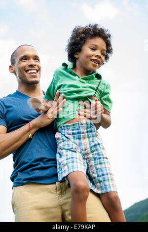 Un homme de lever son fils dans ses bras, jouant à l'extérieur. Banque D'Images