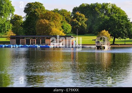 Le Serpentine à Hyde Park, Londres, vue sur l'eau jusqu'à la location de bateaux. Arbres montrant les premiers signes de couleur d'automne. Banque D'Images