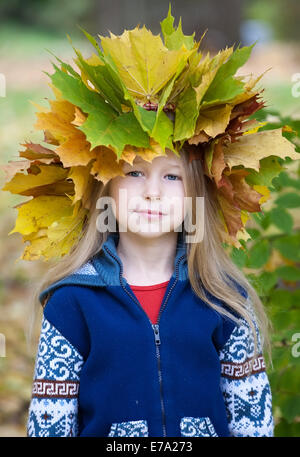 Portrait de belle petite fille de race blanche à l'automne jaune feuilles d'érable couronne Banque D'Images