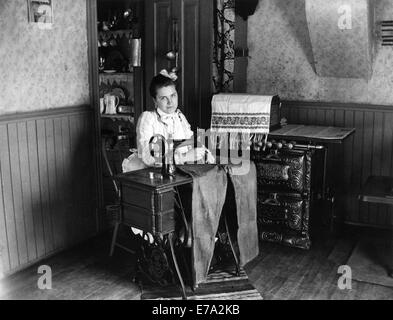 Couture femme pantalon sur machine à coudre, vers 1905 Banque D'Images