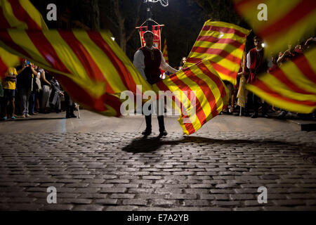 Barcelone, Espagne. 10 Septembre, 2014. Un artiste interprète ou exécutant en agitant des drapeaux catalans dans les rues de Barcelone. Dans la ville de Barcelone a eu plusieurs événements et manifestations en faveur de l'indépendance la nuit avant la célébration de la fête nationale catalane. Le peuple catalan demande un référendum sur l'indépendance du 9 novembre prochain. Crédit : Jordi Boixareu/Alamy Live News Banque D'Images