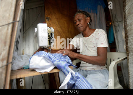 Couturière travaillant sur une machine à coudre dans une hutte, Camp d'Icare, camp de réfugiés du séisme, Fort National, Port-au-Prince, Haïti Banque D'Images