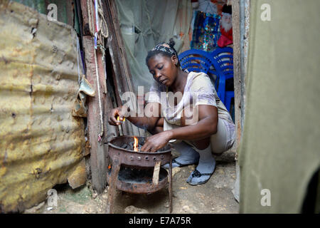 Femme la cuisson dans la cuisine improvisée d'une hutte délabrée, Camp d'Icare, camp de réfugiés du séisme, Fort National Banque D'Images