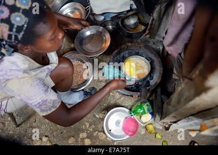 Femme la cuisson dans la cuisine improvisée d'une hutte délabrée, Camp d'Icare, camp de réfugiés du séisme, Fort National Banque D'Images