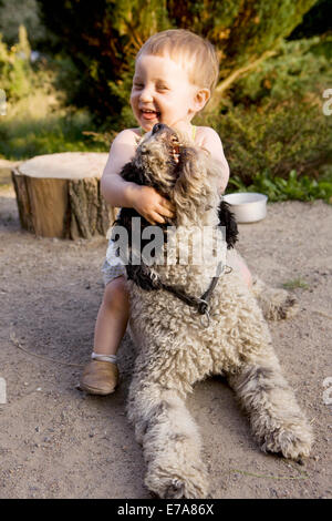 Petite fille jouant avec un chien d'eau Portugais Banque D'Images