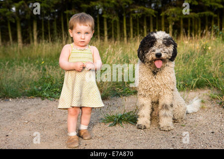 Baby girl avec chien d'eau Portugais, portrait Banque D'Images