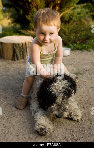 Petite fille jouant avec un chien d'eau Portugais Banque D'Images