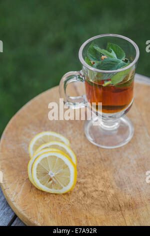 Thé glacé à la menthe par tranches de lime on outdoor table Banque D'Images