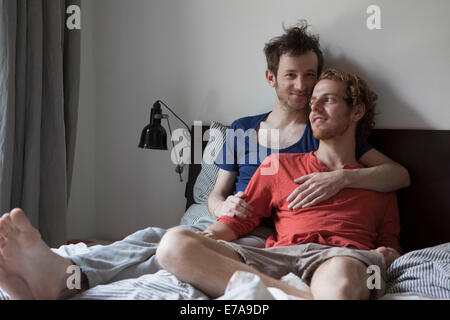L'amour gay couple relaxing in bed at home Banque D'Images