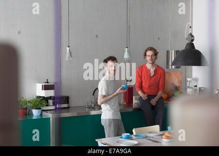 Jeune couple gay à l'écart dans la cuisine Banque D'Images