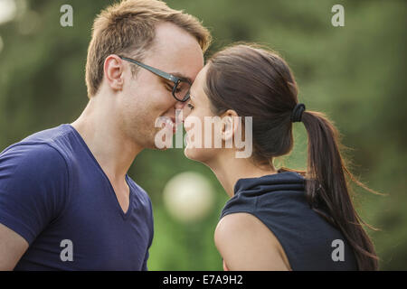 Vue latérale du couple rubbing noses in park Banque D'Images