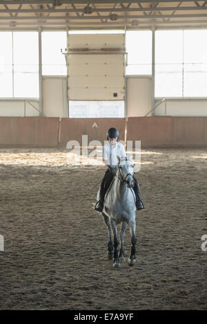 Little Boy riding horse stable dans la formation Banque D'Images